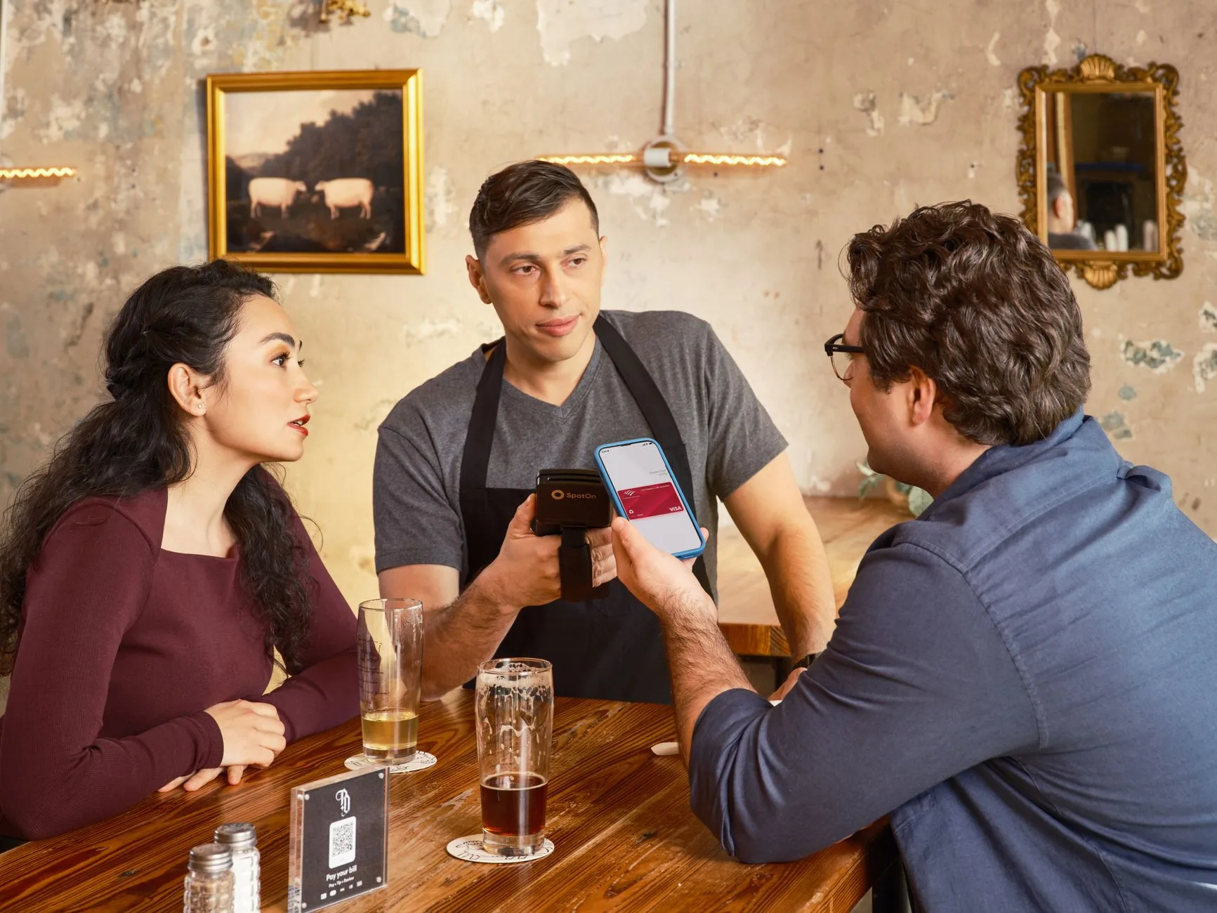 Como criar qr code para cardápio digital de restaurante — Um casal realiza um pagamento sem contato usando um smartphone